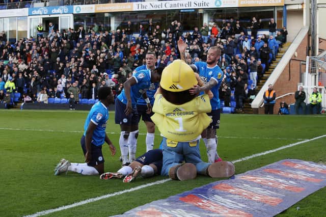 Posh players celebrate a goal for Jonson Clarke-Harris against Exeter with a Mick George mascot. Photo: Joe Dent/theposh.com.