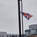 A flag flies from one cable tie on the Rivergate Roundabout near the Town Hall