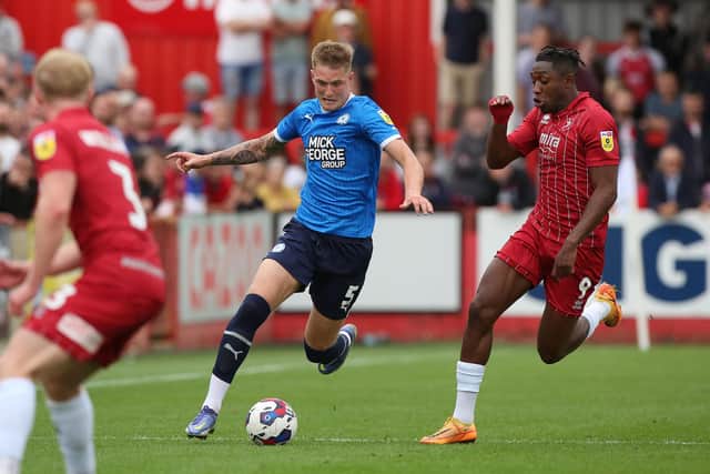 Josh Knight of Peterborough United in action with Dan N'Lundulu of Cheltenham Town. Photo: Joe Dent/theposh.com