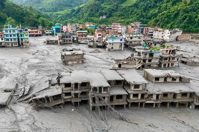 An aerial view shows houses lying deluged in sludge after flash floods at Devighat, Bidur Municipality in Nepal's Nuwakot district on August 27, 2026. (Photo by Prabin RANABHAT / AFP via Getty Images).