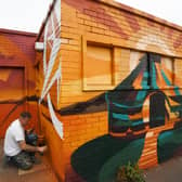 Nathan Murdoch re-painting the old toilet block on the Embankment