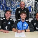 Reuben Marshall (centre. front) signs his first professional contract flanked by Posh Academy staff. Photo: Joe Dent/theposh.com.