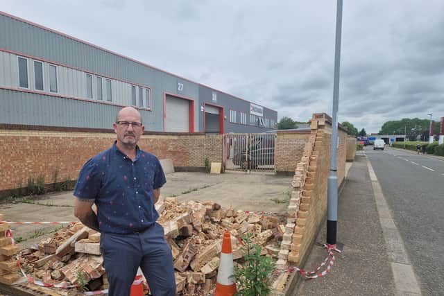 Warehouse manager Steve Butler, next to the wall which was destroyed by a car drifting on Tresham Road