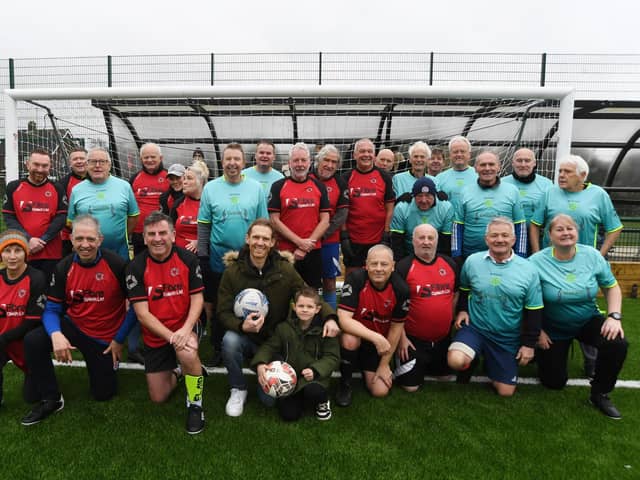 Craig Mackail-Smith (front, centre), with his son Jude, alongside Netherton walking football teams at the official opening of the new 3G pitch at The Grange. Photo: David Lowndes.