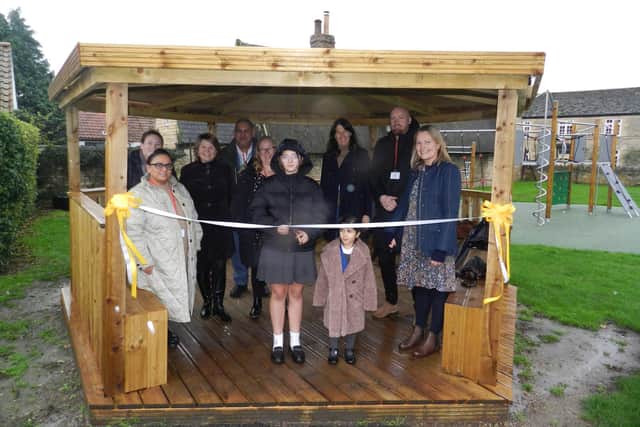 Pupils, staff and benefactors join Head Teacher Alice Edwards (third left) and bespoke builder Stuart Hendry (second right) to open Castor School's new outdoor classroom and play area.