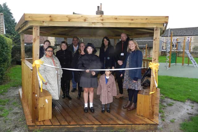 Pupils, staff and benefactors join Head Teacher Alice Edwards (third left) and bespoke builder Stuart Hendry (second right) to open Castor School's new outdoor classroom and play area.