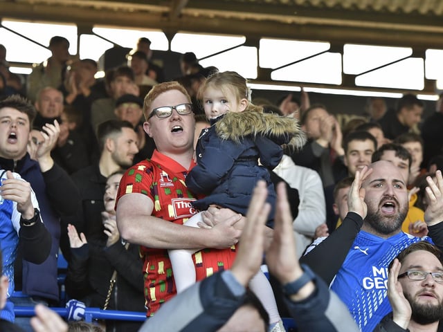 Peterborough United fans are pictured watching the crucial win over Derby County.