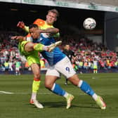 Jonson Clarke-Harris of Peterborough United battles with Joe Worrall of Nottingham Forest. Photo: Joe Dent/theposh.com.