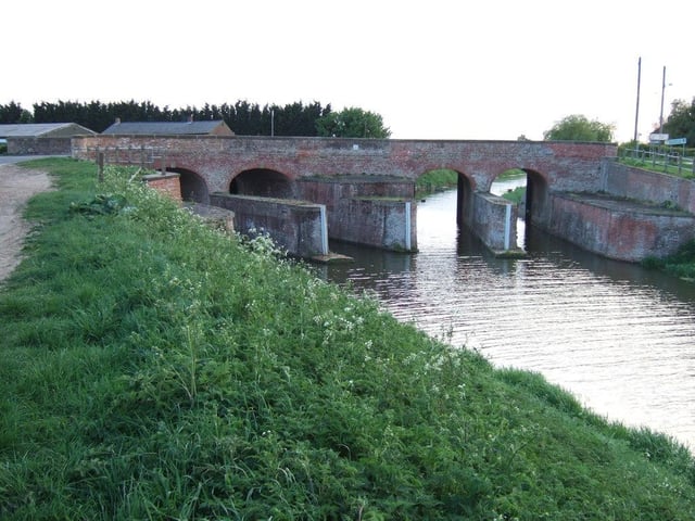 The double bridge at Parson's Drove joins Cambridgeshire to Lincolnshire. At this point the North Level Main Drain splits into two. The structure, which acts as both a bridge and a sluice, was built in the 1830s for drainage purposes. It was listed by Historic England in 1983.