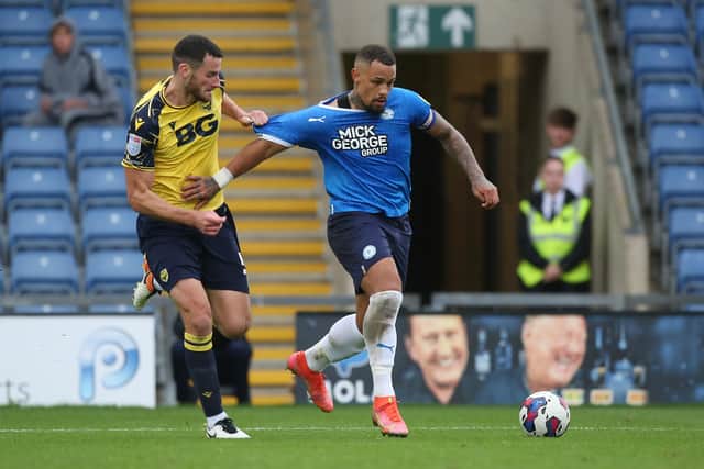 Jonson Clarke-Harris of Peterborough United battles with Elliott Moore of Oxford United. Photo: Joe Dent/theposh.com.