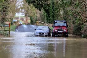 Bill Clarke offers help to a motorist stuck in the flood. Photo: Alison Bagley.