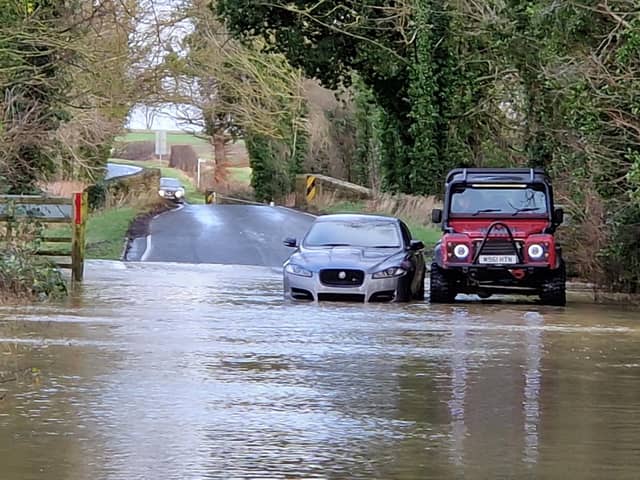 Bill Clarke offers help to a motorist stuck in the flood. Photo: Alison Bagley.