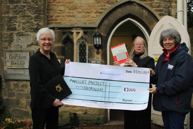 Peterborough Choir Chair Margaret Wilson (right) and Publicity Manager Mimi Lawrence (centre) presenting a cheque for £1000 to a representative of the Peterborough Light Project, which supports the poor and homeless in the City of Peterborough'.