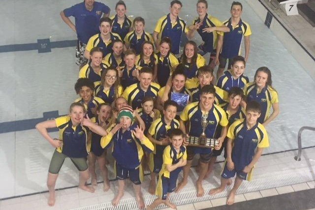 Swimmers from City of Peterborough Swimming Club pose for a picture at an event.