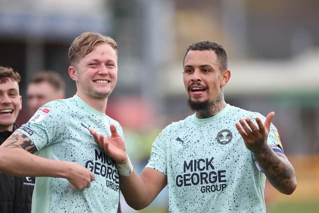 Jonson Clarke-Harris of Peterborough United celebrates the win at Lincoln at full-time with team-mate Frankie Kent. Photo: Joe Dent/theposh.com.