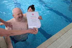 Jimmy is happy to receive a certificate for completing his swim challenge.