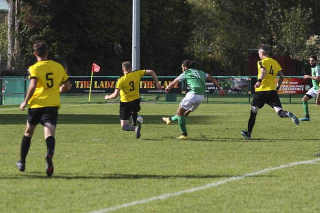 Vitor Vaz (green) scores for FC Peterborough against Crowland. Photo: Tim Symonds