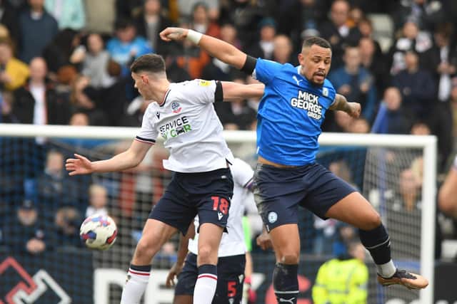 Posh skipper Jonson Clarke-Harris in an aerial duel against Bolton. Photo: David Lowndes.