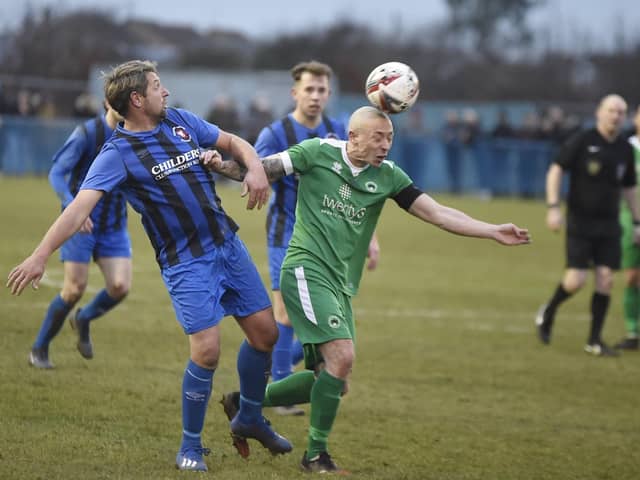 Whittlesey Athletic player-manager Ricky Hailstone (blue) in FA Vase action against Newport Pagnell last season. Photo: David Lowndes.