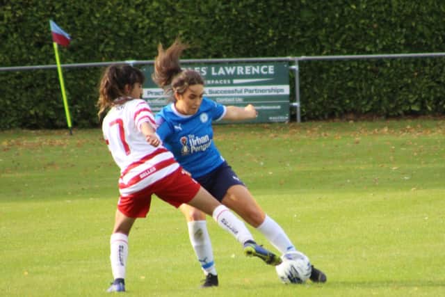 Tara Kirk (blue) in action for Posh v Doncaster Belles at Bourne Town FC. Photo: Jason Richardson