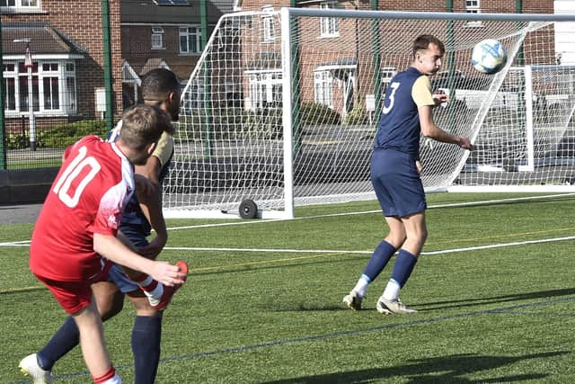 Junior Cup action from the game between Youth  Dreams Project and Stamford AFC Reserves (red). Photo: David Lowndes.