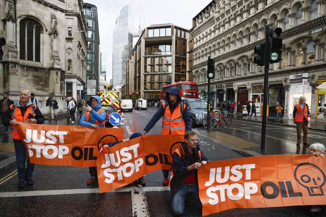 Just Stop Oil  protesters blocking a road  in London.
(Photo by Jeff J Mitchell/Getty Images)