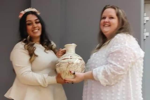 Malika Speaks (left) handing the title and commemorative jug over to Kat Beeton (right).
