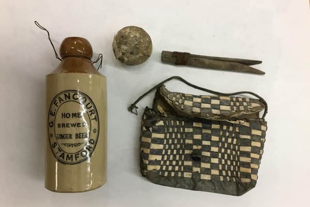 Historical finds were unearthed during roof repairs at Stamford Library. A Stamford ginger beer stoneware bottle, tools, a bag or satchel and a shoe were found under the rafters - which are thought to date back to the 19th Century.