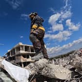 A rescue worker stands amid the rubble of a building in the rebel-held town of Jindayris on February 10, 2023, days after an earthquake hit Turkey and Syria. - The 7.8-magnitude quake early on February 6 has killed more than 20,000 people in Turkey and war-ravaged Syria, according to officials and medics in the two countries, flattening entire neighbourhoods. (Photo by Rami al SAYED / AFP) (Photo by RAMI AL SAYED/AFP via Getty Images)