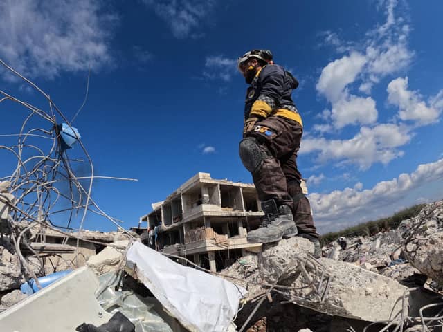 A rescue worker stands amid the rubble of a building in the rebel-held town of Jindayris on February 10, 2023, days after an earthquake hit Turkey and Syria. - The 7.8-magnitude quake early on February 6 has killed more than 20,000 people in Turkey and war-ravaged Syria, according to officials and medics in the two countries, flattening entire neighbourhoods. (Photo by Rami al SAYED / AFP) (Photo by RAMI AL SAYED/AFP via Getty Images)