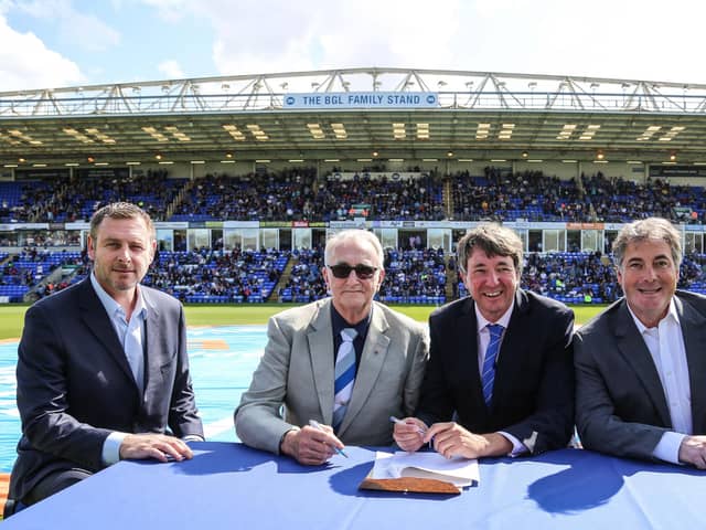 Peterborough United Co-Owners Stewart Thompson, Darragh MacAnthony and Jason Neale along with Councillor John Holdich, former Leader of Peterborough City Council on the pitch during a contract signing ceremony in 2020.