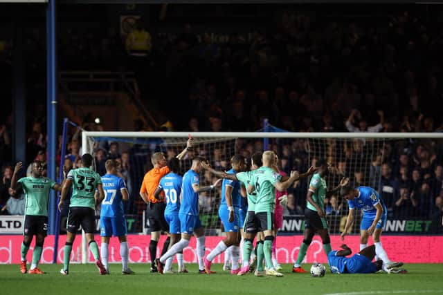 Referee Scott Oldham shows the red card to James Olayinka of Cheltenham Town. Photo: Joe Dent.