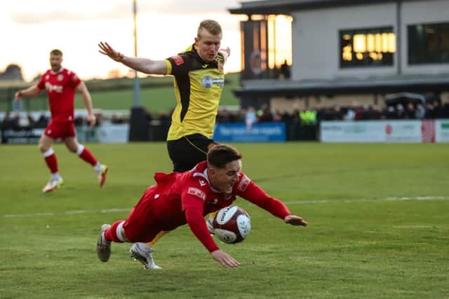 Harry Vince of Stamford goes down in the penalty area. Photo: Rob O'Brien.
