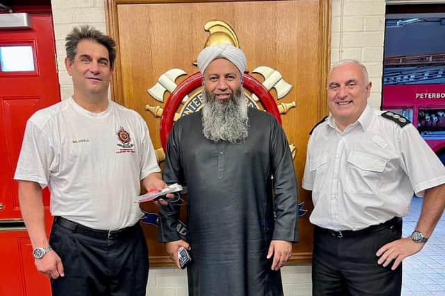 Peterborough Volunteer Fire Brigade second officer Anthony Gould (left), chief officer Tony De Matteis (right) and Mohammed Saeed (centre), who donated the phone on behalf of local business Handtec