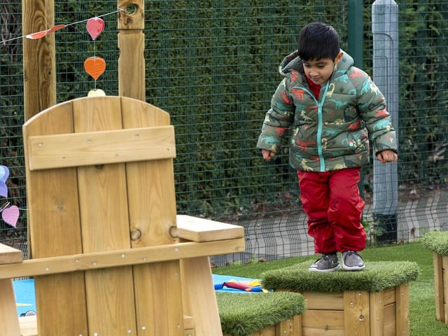 A pupil enjoys some of the new wooden climbing equipment.