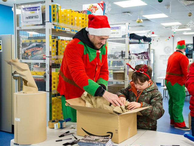 Amazon employees and their families helping to wrap presents for the children of Embrace Child Victims of Crime