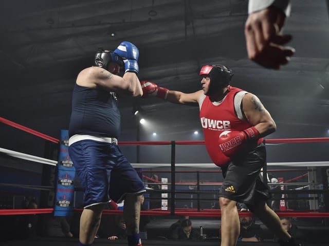 Jay Robbie Packman (red) lands a punch on opponent Wesley White (blue).