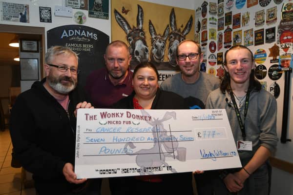 Wonky Donkey fundraisers  Dave and Andrew Williams with James and Martin Renfree-Reeve hand over a cheque to Uljana Volosina of Cancer Research