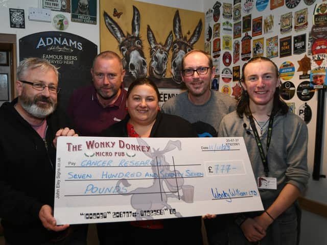 Wonky Donkey fundraisers  Dave and Andrew Williams with James and Martin Renfree-Reeve hand over a cheque to Uljana Volosina of Cancer Research