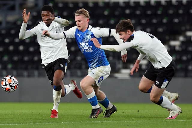 Kellan Hickinson (blue) in action for Posh Youths. Photo: Joe Dent/theposh.com.