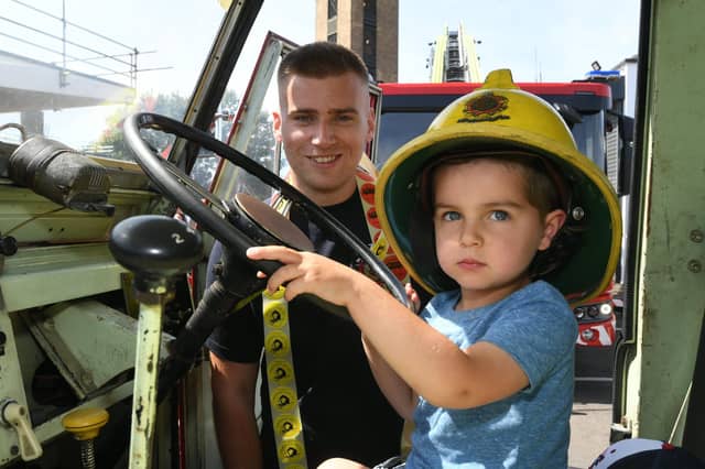 Firefighter Josh Berrisford and Toby Schlevitz (3) in vintage fire engine.