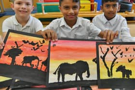 Longthorpe primary school pupils  Abdullah Ali, Eisa Ali and Alfie James selling artwork to raise funds for the World Wildlife Fund.

