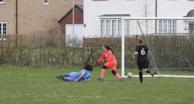 Larissa Frederick (blue) scores for Peterborough Sports against Isleham. Photo: Tim Symonds