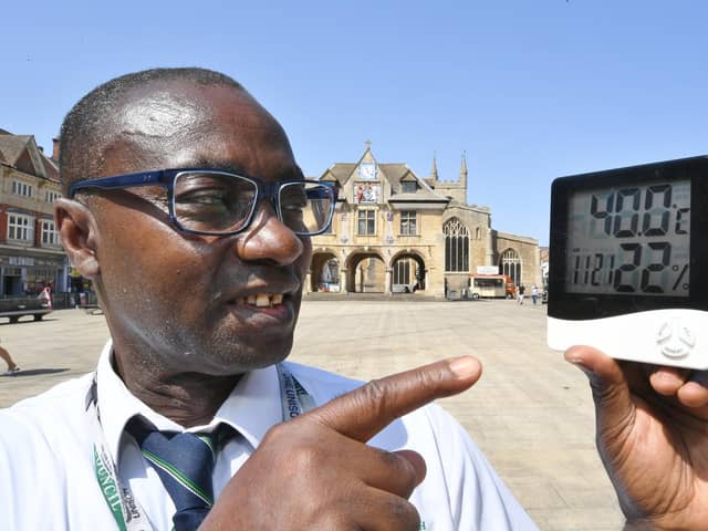 Ernest Mensah-Sekyere with a digital thermometer reading 40 degrees in direct sunlight at Cathedral Square in 2022.




NY22