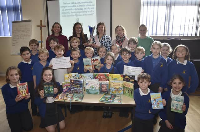 Carole Hughes with Anna's Hope volunteers presenting book prizes to staff and pupils at Castor C of E Primary School following their fundraising for the charity