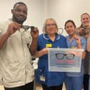 Staff from North West Anglia NHS Foundation Trust’s ophthalmology department with one of the Specs for Africa collecting boxes