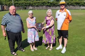 Norma Squires (left) and Sheron Noble with the memorial shield remembering their late husbands flanked by Hunts Bowls team manager Bob Morton (left) and Northants Bowling Federation chairman Martyn Dolby (right).