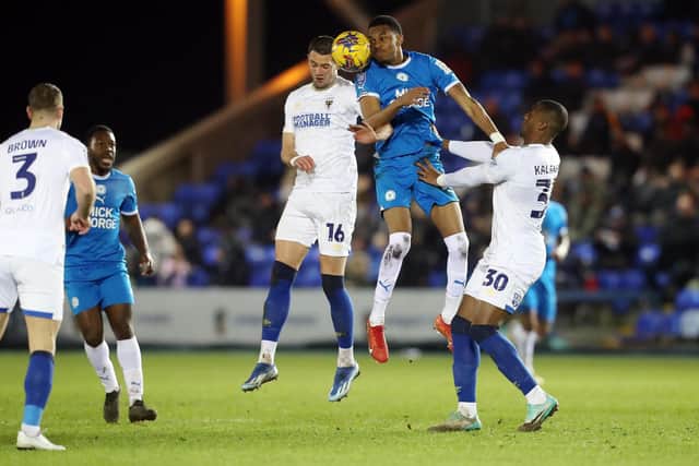 Malik Mothersille of Peterborough United challenges for a header with James Ball of AFC Wimbledon. Photo: Joe Dent.