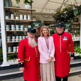 Designer Sophie Allport with two Chelsea Pensioners at her trade stand at the Chelsea Flower Show.