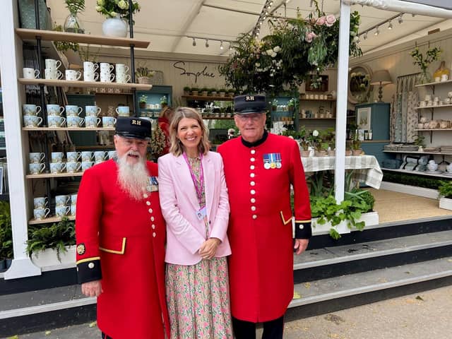 Designer Sophie Allport with two Chelsea Pensioners at her trade stand at the Chelsea Flower Show.